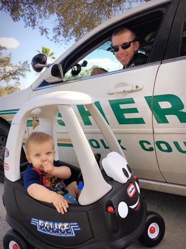 Deputy in patrol car with child in toy car